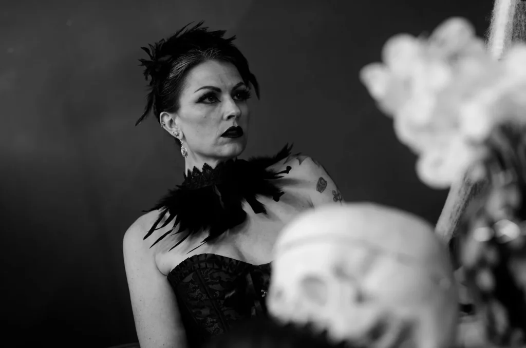 Woman in a corset with a feather collar in a black-and-white portrait – protecting privacy